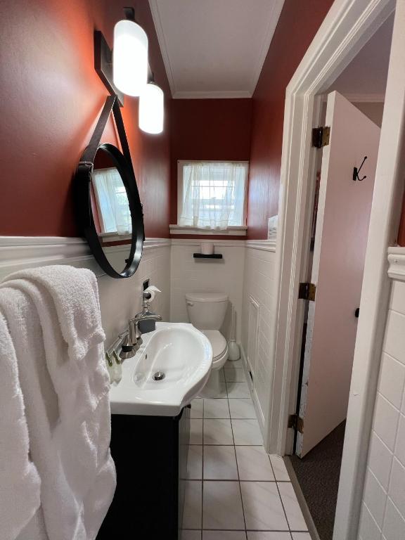 a bathroom with a sink and a toilet and a mirror at Inn at the Falls in Bracebridge