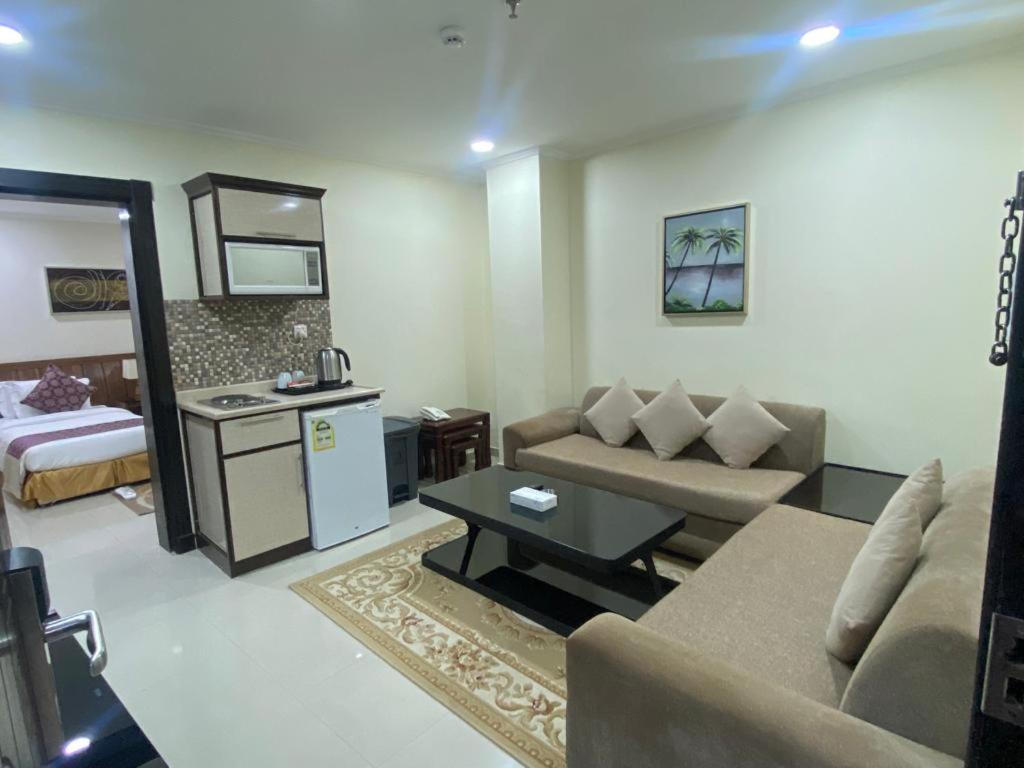 a living room with a couch a table and a kitchen at Burj Alawal in Al Jubail