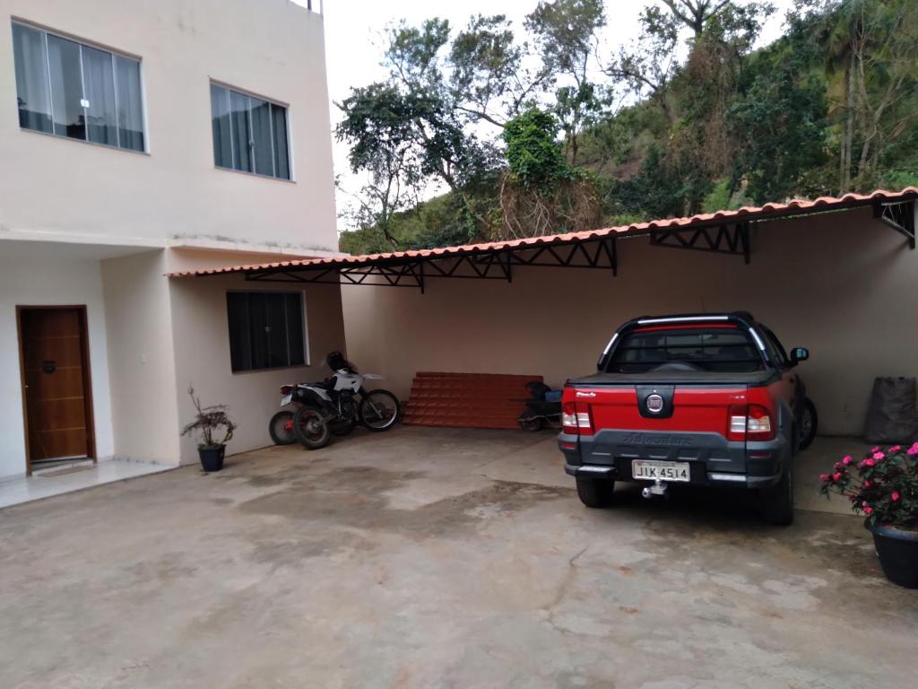 a red truck parked in front of a house at hospedagem recanto do sábia 4 in Alto Caparao