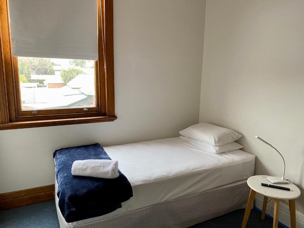 a small bedroom with a bed and a window at Seven Seas Hotel in Carrington