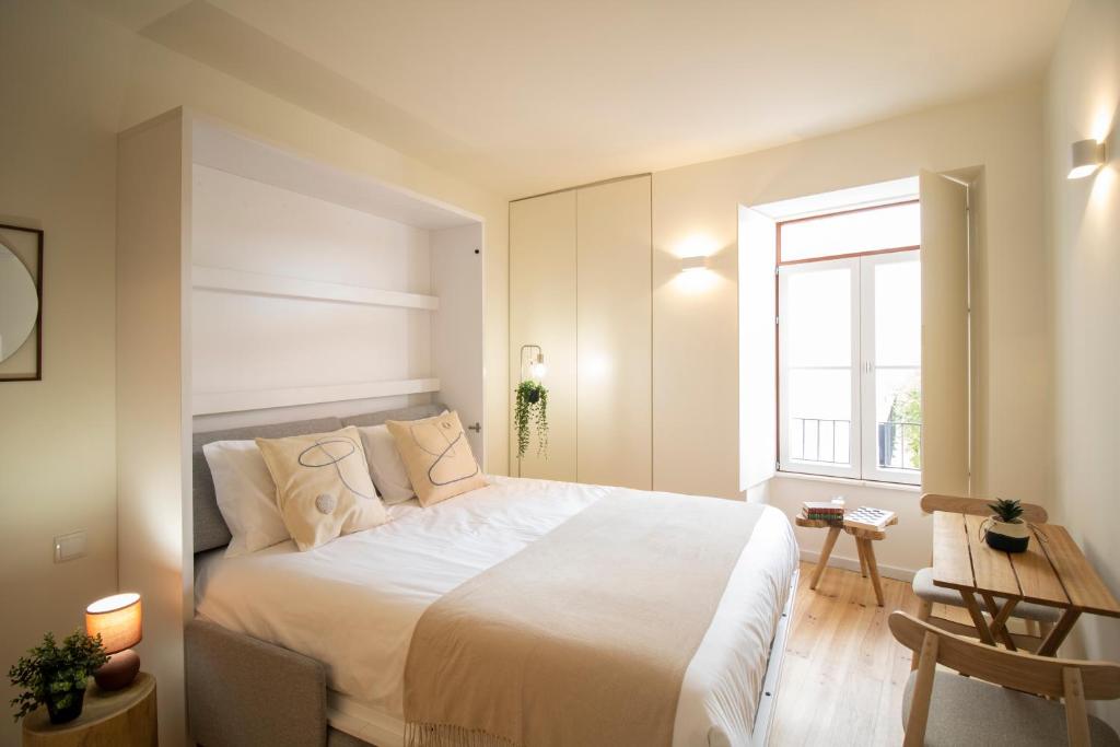 - une chambre avec un grand lit blanc et une fenêtre dans l'établissement Casa do Postal @ Casas do Pátio (5), à Coimbra