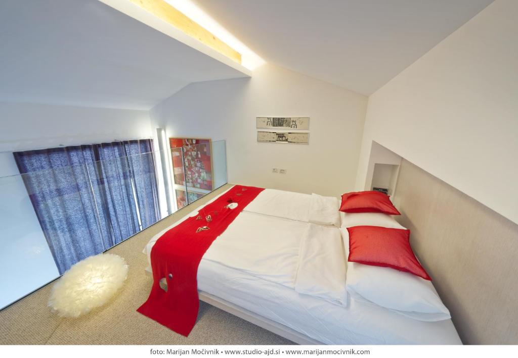 1 dormitorio con 1 cama con manta roja y blanca en Villa Alma Vista en Dobrovo