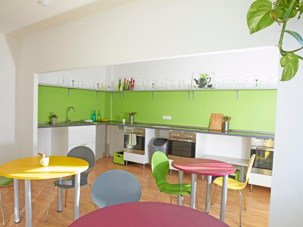 a kitchen with two tables and colorful chairs at PM-Rooms in Munich