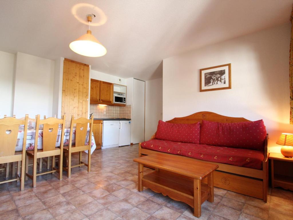 uma sala de estar com um sofá vermelho e uma mesa em Appartement Lanslevillard, 3 pièces, 6 personnes - FR-1-508-12 em Lanslevillard