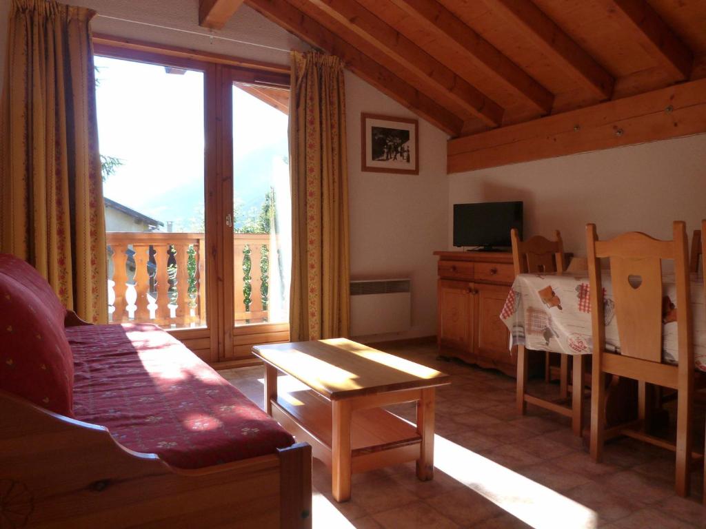 d'un salon avec un canapé et un balcon. dans l'établissement Appartement pour 6 au centre de Lanslevillard, proche des pistes avec balcon et WIFI - FR-1-508-15, à Lanslevillard