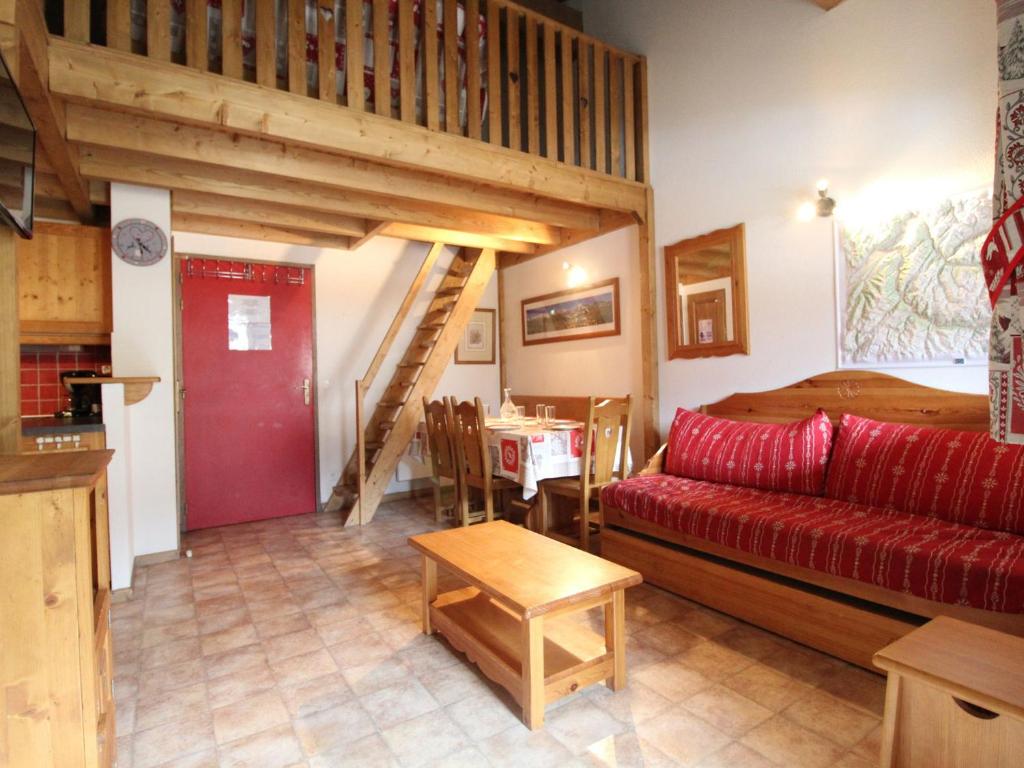 un salon avec un canapé rouge et une table dans l'établissement Appartement Au Pied des Pistes pour 6 Personnes - Appartement Confortable à Val Cenis - FR-1-508-44, à Lanslevillard