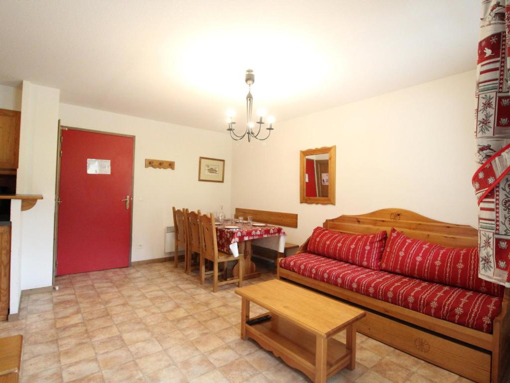 a living room with a red couch and a table at Appartement Lanslevillard, 3 pièces, 6 personnes - FR-1-508-53 in Lanslevillard