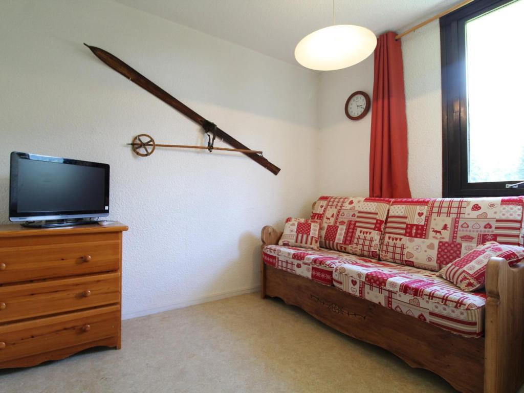 a living room with a couch and a tv at Studio 3 pers. au pied des pistes avec balcon exposé sud, draps fournis, proche commerces - FR-1-508-76 in Lanslevillard