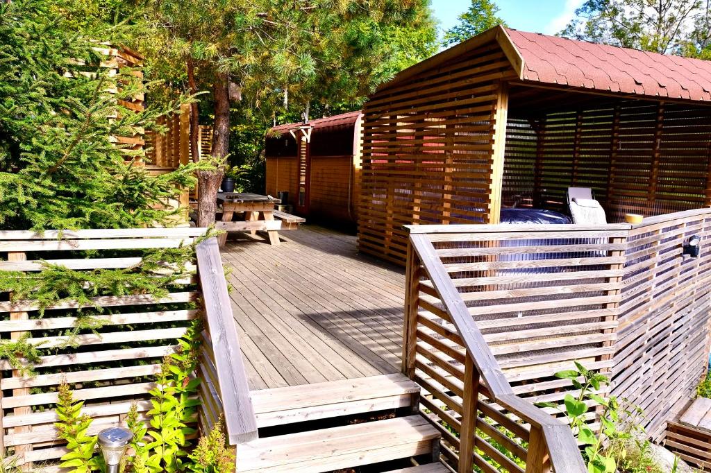 una terraza de madera con una cabaña de madera con un banco en B&B KNARDAL SPA en Neset