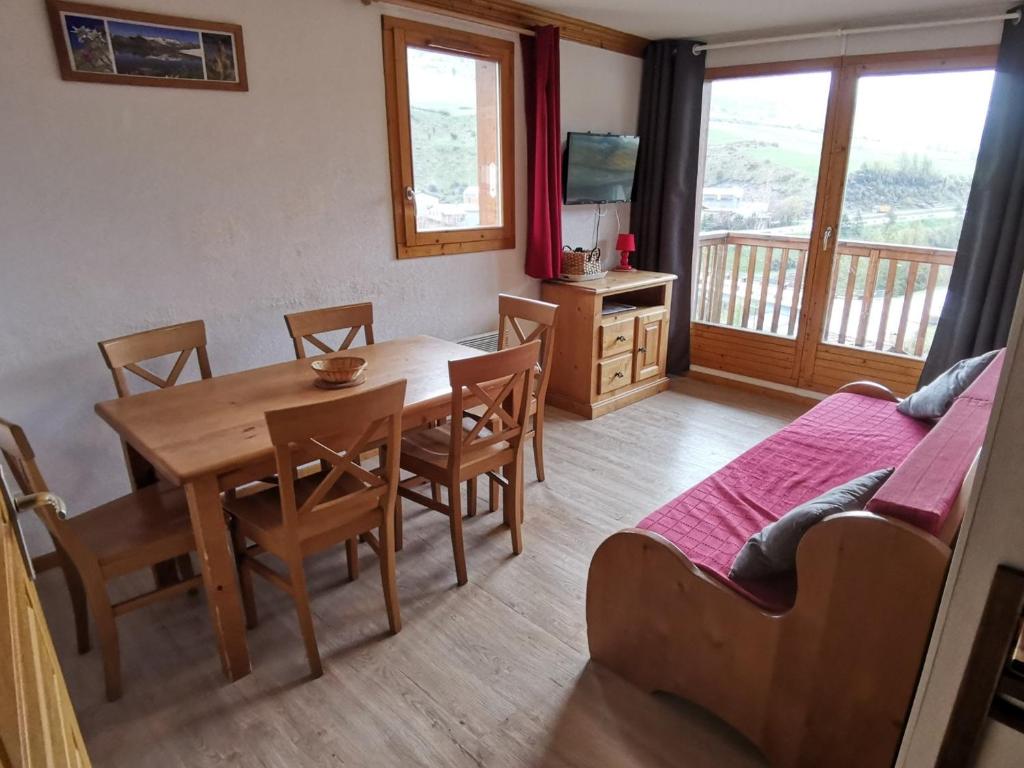 une salle à manger avec une table, des chaises et un canapé dans l'établissement Appart 6 pers avec piscine, skis, ascenseur à Lanslebourg - FR-1-508-93, à Lanslebourg-Mont-Cenis
