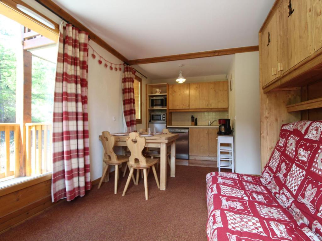 a living room with a table and a kitchen at Appartement Lanslebourg-Mont-Cenis, 3 pièces, 6 personnes - FR-1-508-78 in Lanslebourg-Mont-Cenis