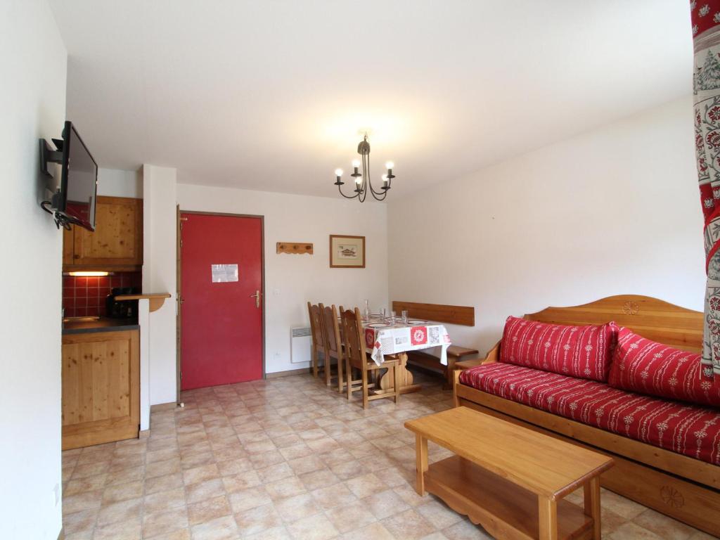 un salon avec un canapé rouge et une table dans l'établissement Appartement spacieux pour 6 personnes, balcon exposé plein sud, pied des pistes à Val Cenis - FR-1-508-104, à Lanslevillard