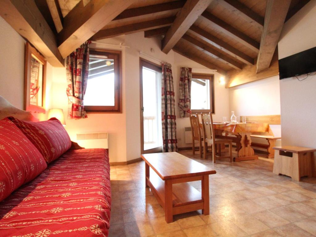 a living room with a red couch and a table at Appartement Lanslevillard, 2 pièces, 4 personnes - FR-1-508-145 in Lanslevillard