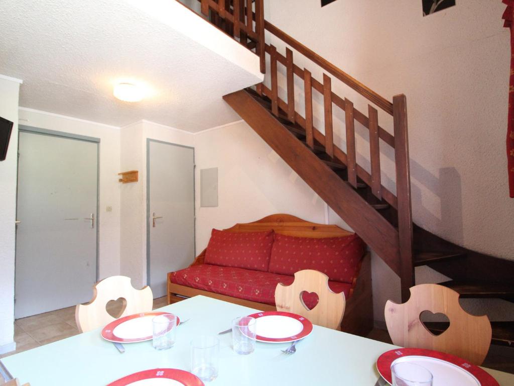 a living room with a table and a red couch at Appartement Lanslevillard, 1 pièce, 5 personnes - FR-1-508-82 in Lanslevillard