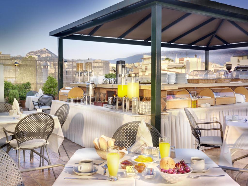 una mesa con comida y bebida en el balcón en Jason Inn, en Atenas