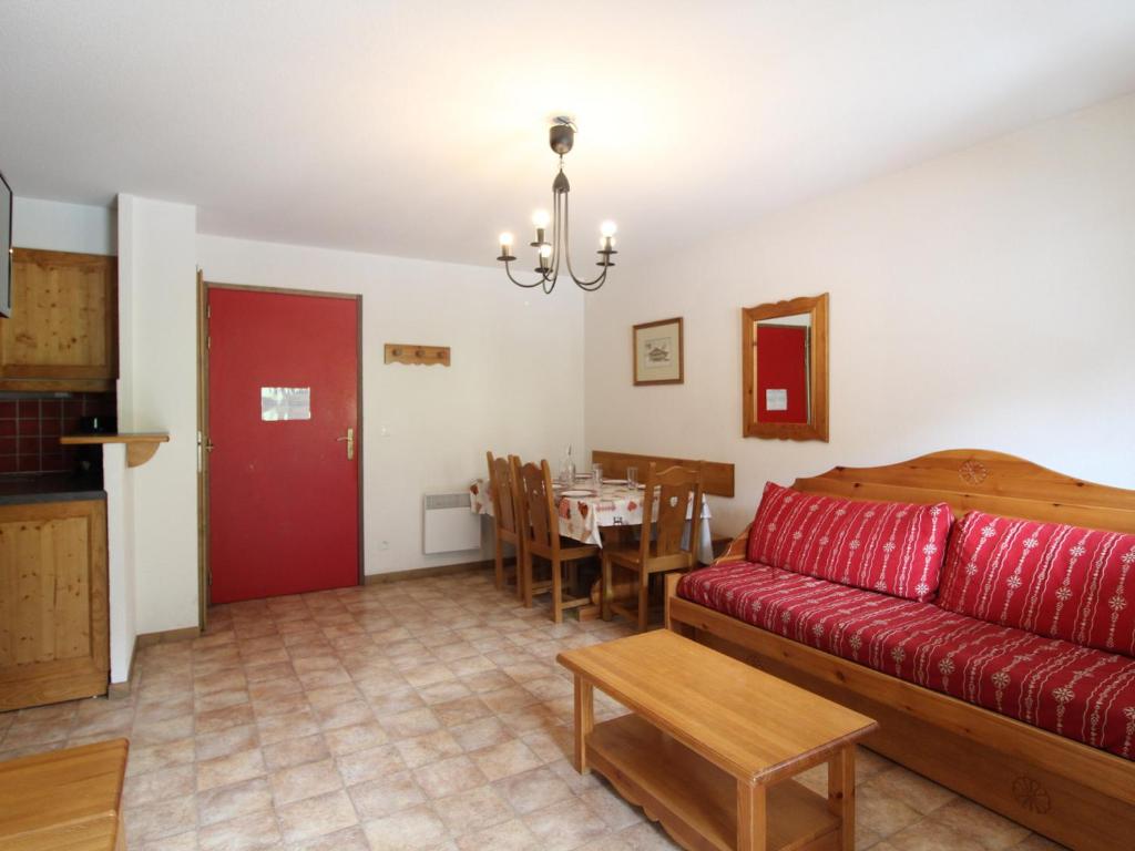 un salon avec un canapé rouge et une table dans l'établissement Appartement 6 personnes, Val-Cenis, au pied des pistes avec parking et WiFi - FR-1-508-113, à Lanslevillard