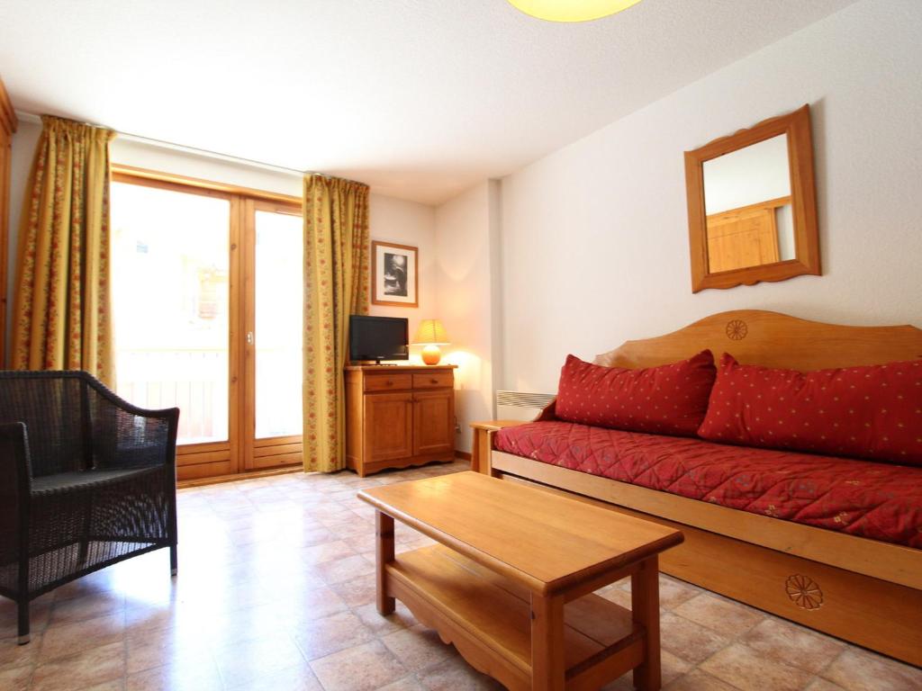 a living room with a red couch and a table at Appartement Lanslevillard, 2 pièces, 6 personnes - FR-1-508-107 in Lanslevillard