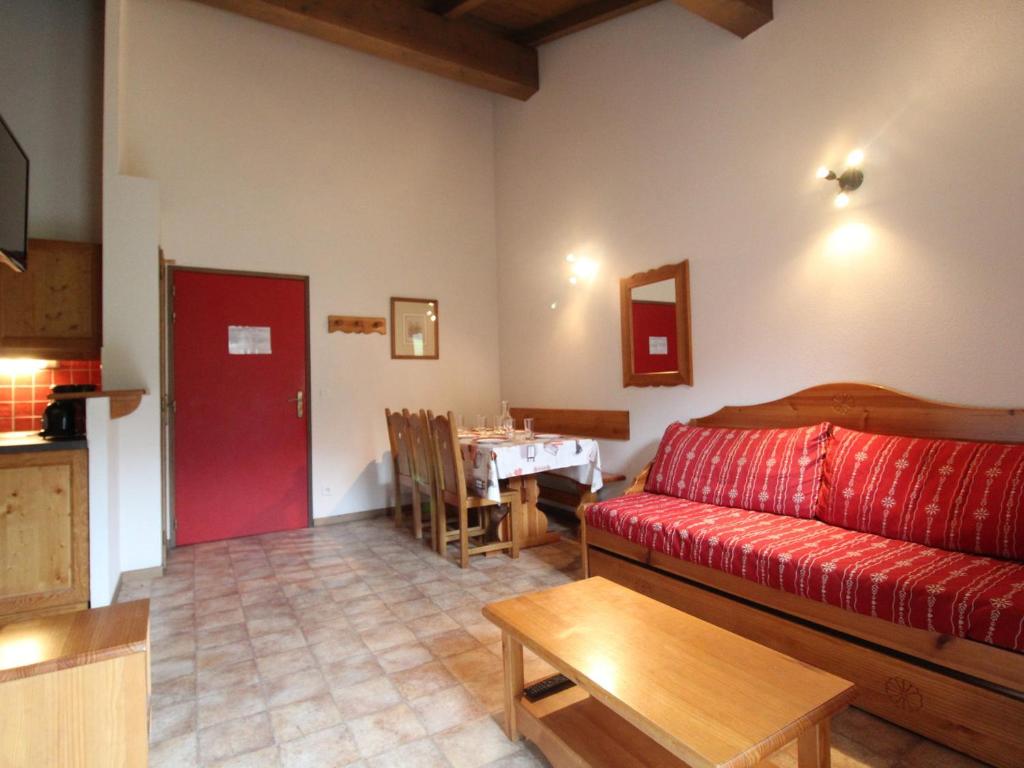 un salon avec un canapé rouge et une table dans l'établissement Appartement cosy 6 pers à Val Cenis, au pied des pistes, proche commerces et services - FR-1-508-111, à Lanslevillard