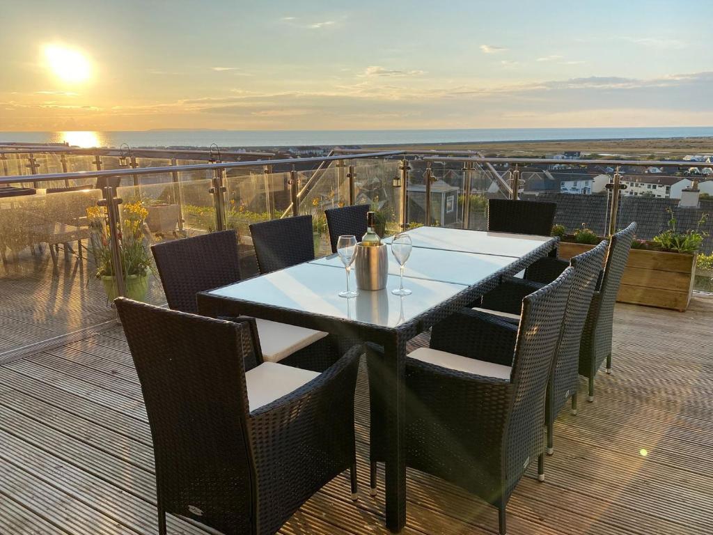 a table and chairs on a balcony with a view at Atlantic View in Westward Ho