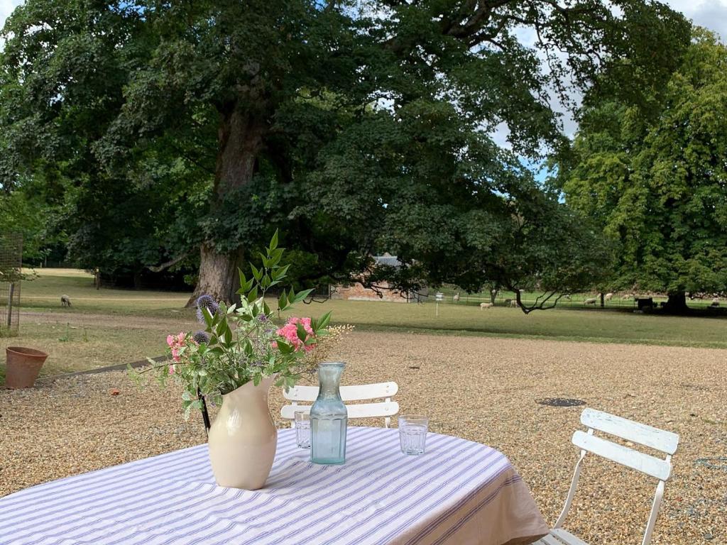 uma mesa com um vaso e flores em The Stable em Womenswold