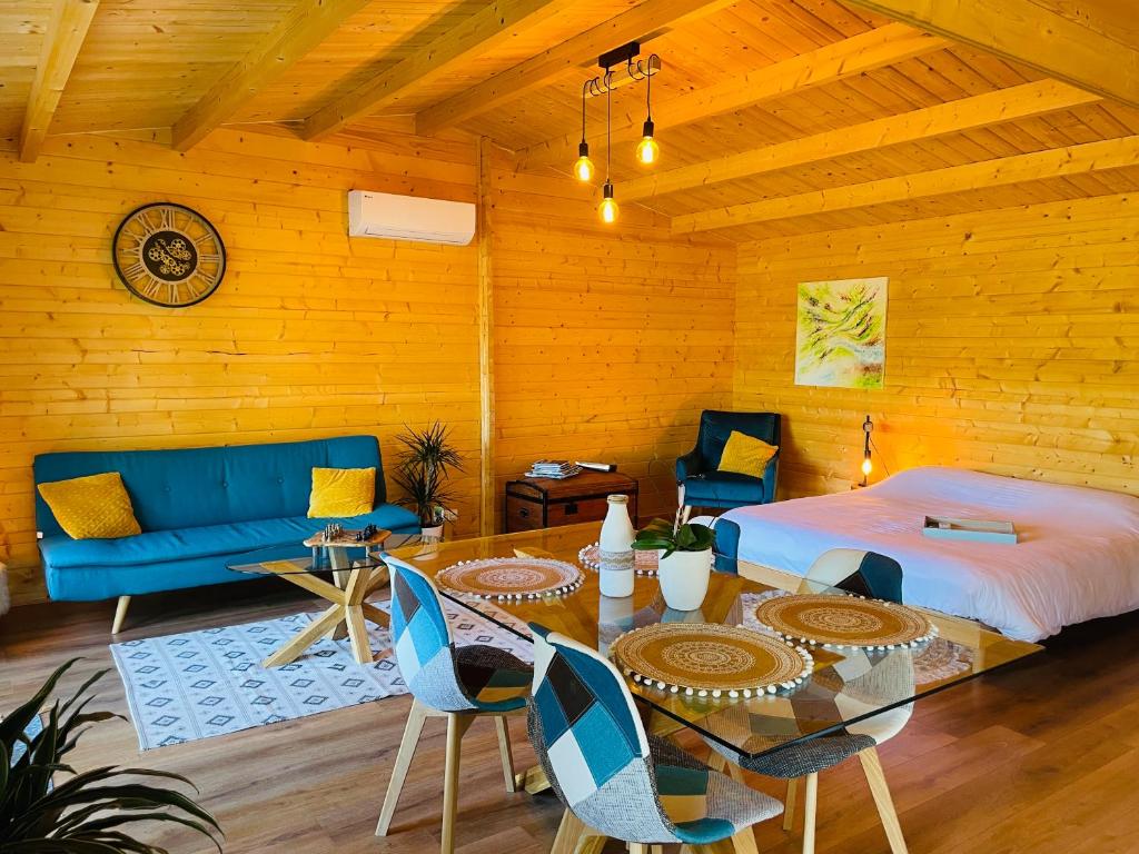1 dormitorio con 1 cama, mesa y sillas en Chalet Loda cosy spa privé en Roussayrolles