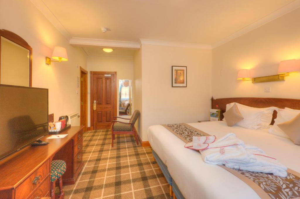 a hotel room with a bed and a flat screen tv at Muthu Alexandra Hotel in Oban