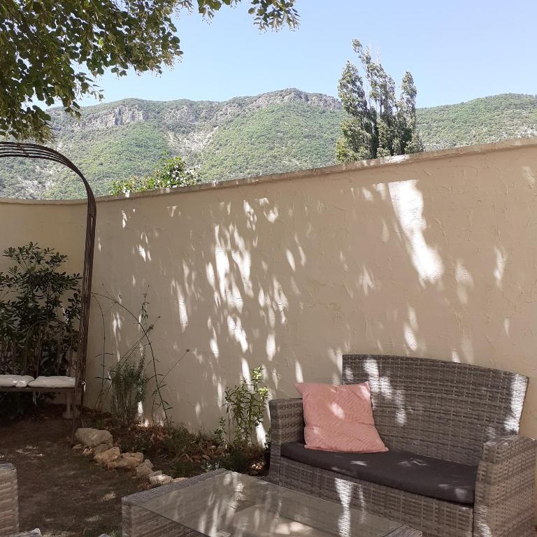 un canapé avec un oreiller rose assis à côté d'un mur dans l'établissement Alma Bella, à Le Péage