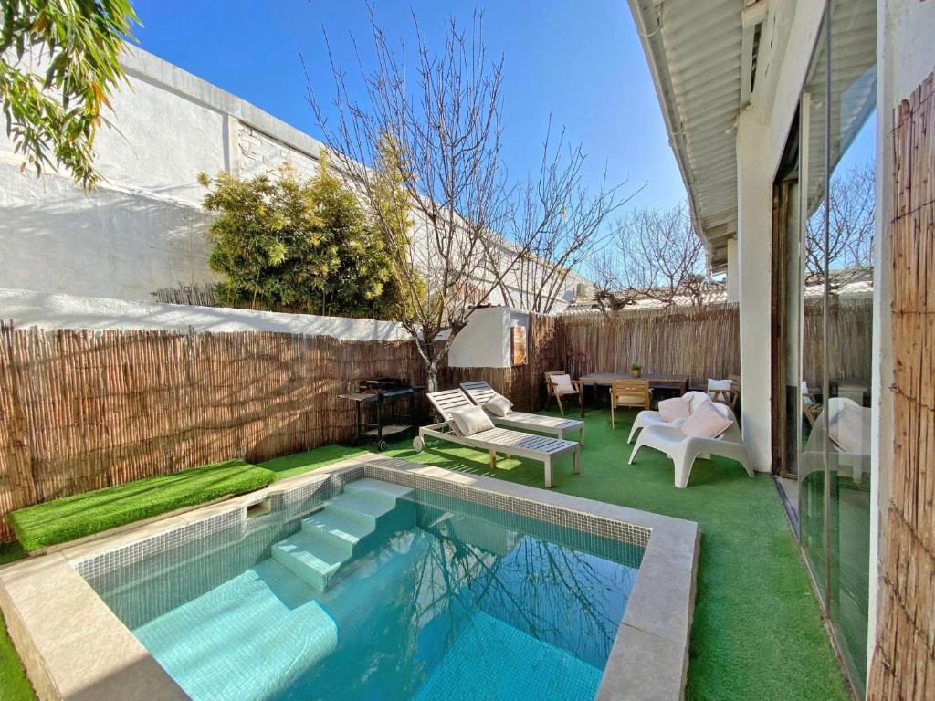 een achtertuin met een zwembad en een hek bij Casa Lavander in Barcelona