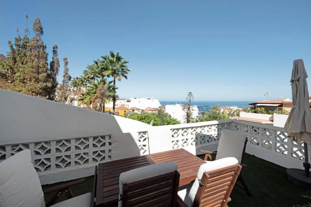 balcón con mesa, sillas y vistas al océano en Casa Sol 21 A Garachico en Garachico