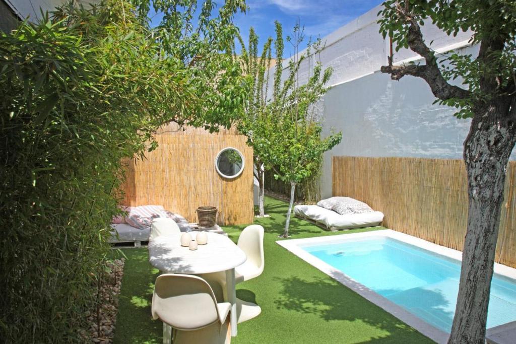 un pequeño patio trasero con piscina, mesa y sillas en Villa Alba, en Barcelona