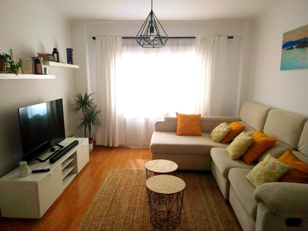 sala de estar con sofá y TV en El Apartamento de Marta, en A Coruña