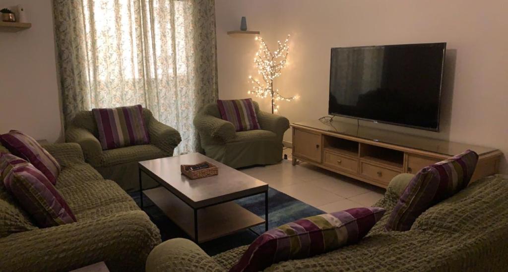 a living room with two couches and a flat screen tv at King Abdullah Economic City Apartment - KAEC شقة بمدينة الملك عبدالله الاقتصادية- حي الواحة in King Abdullah Economic City