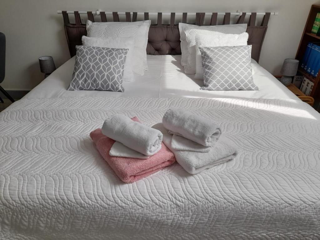 łóżko z ręcznikami i poduszkami w obiekcie Chambre d'hote chez Maud w mieście Saint-Sauveur-Marville