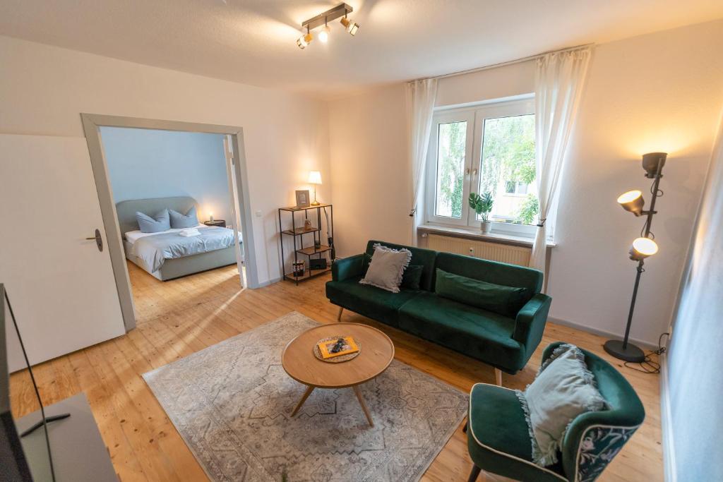 ein Wohnzimmer mit einem grünen Sofa und einem Tisch in der Unterkunft RR - Central Apartment 80qm - Balcony - Washer in Magdeburg