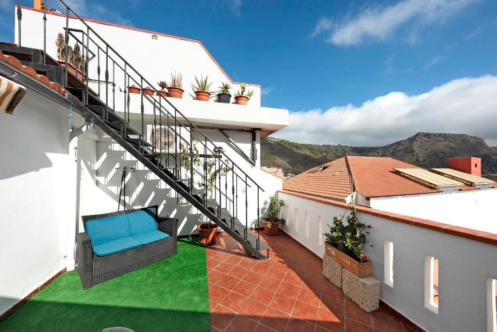 a balcony with a blue chair on a house at Ático El Agua in Santiago del Teide