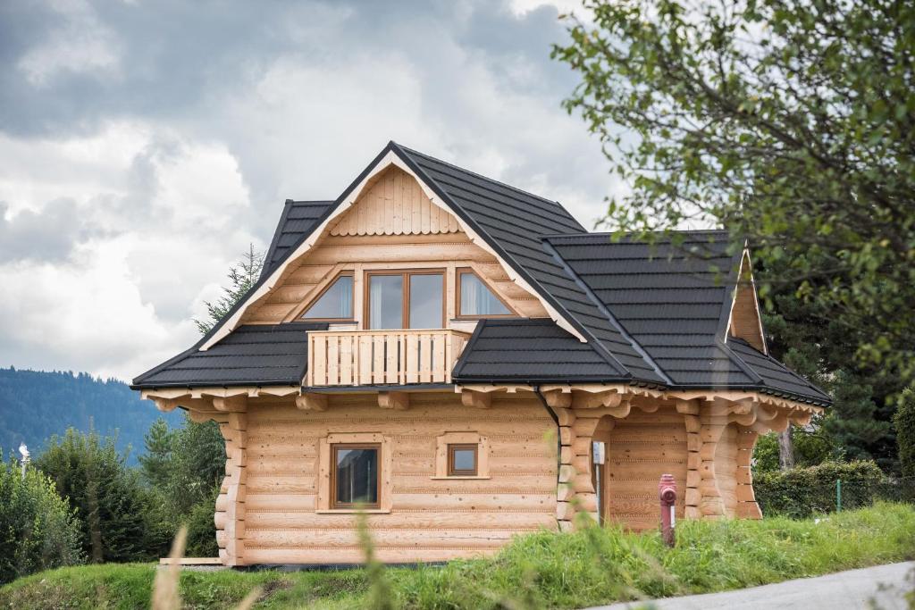 une cabane en rondins avec un toit noir dans l'établissement Grojcówka, à Żywiec
