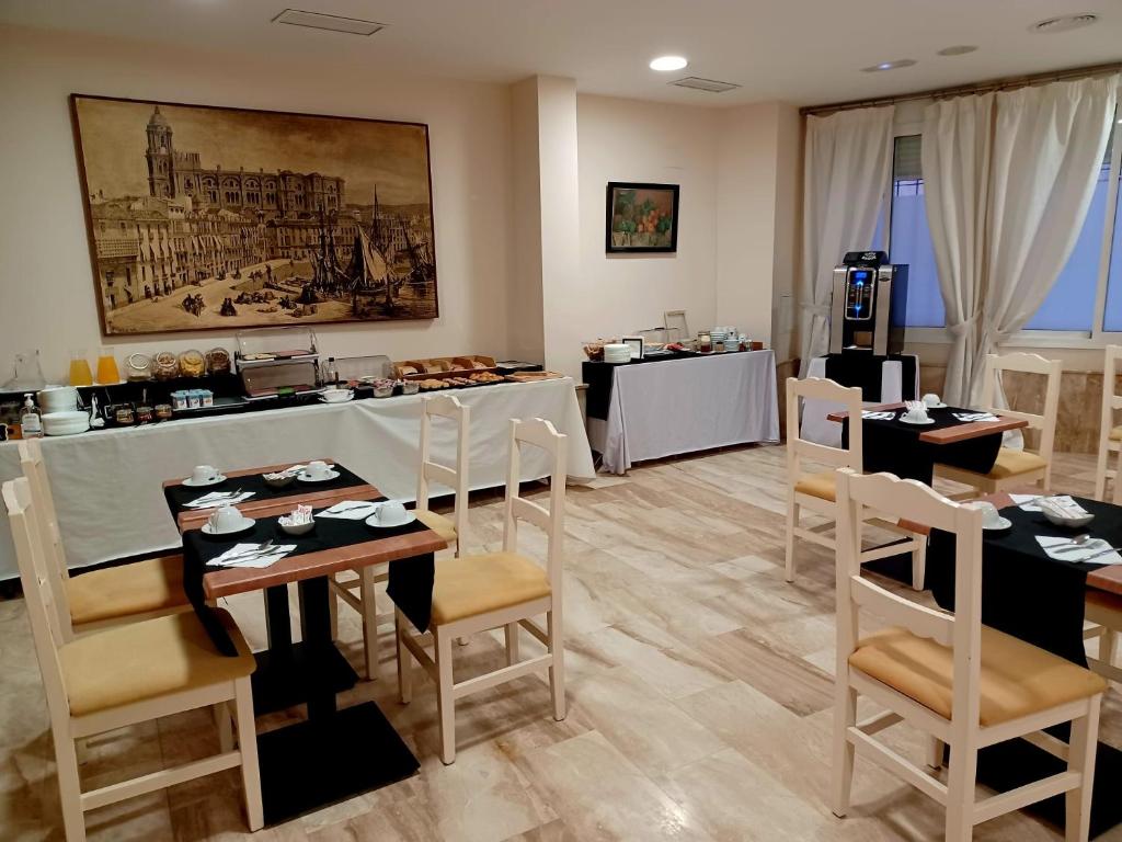 een restaurant met tafels en stoelen en een bar bij Carlos V Malaga in Málaga