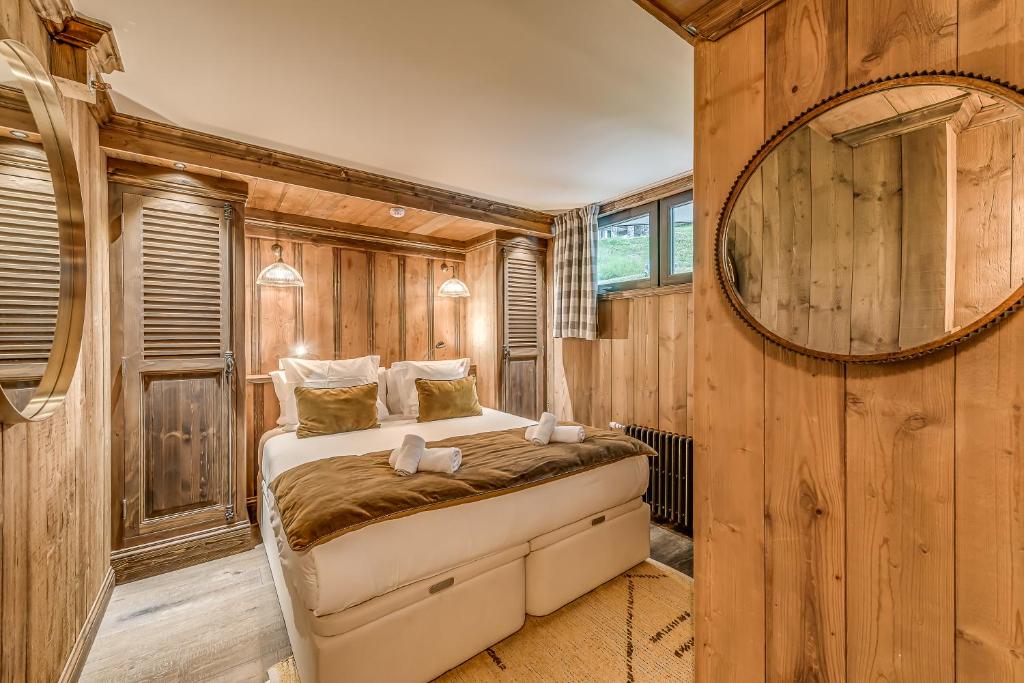 a bedroom with a bed in a room with wooden walls at HOTEL LE VAL D&#39;ISERE in Val-d&#39;Isère