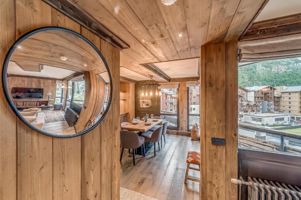 a mirror on a wooden wall in a dining room at HOTEL LE VAL D&#39;ISERE in Val-d&#39;Isère