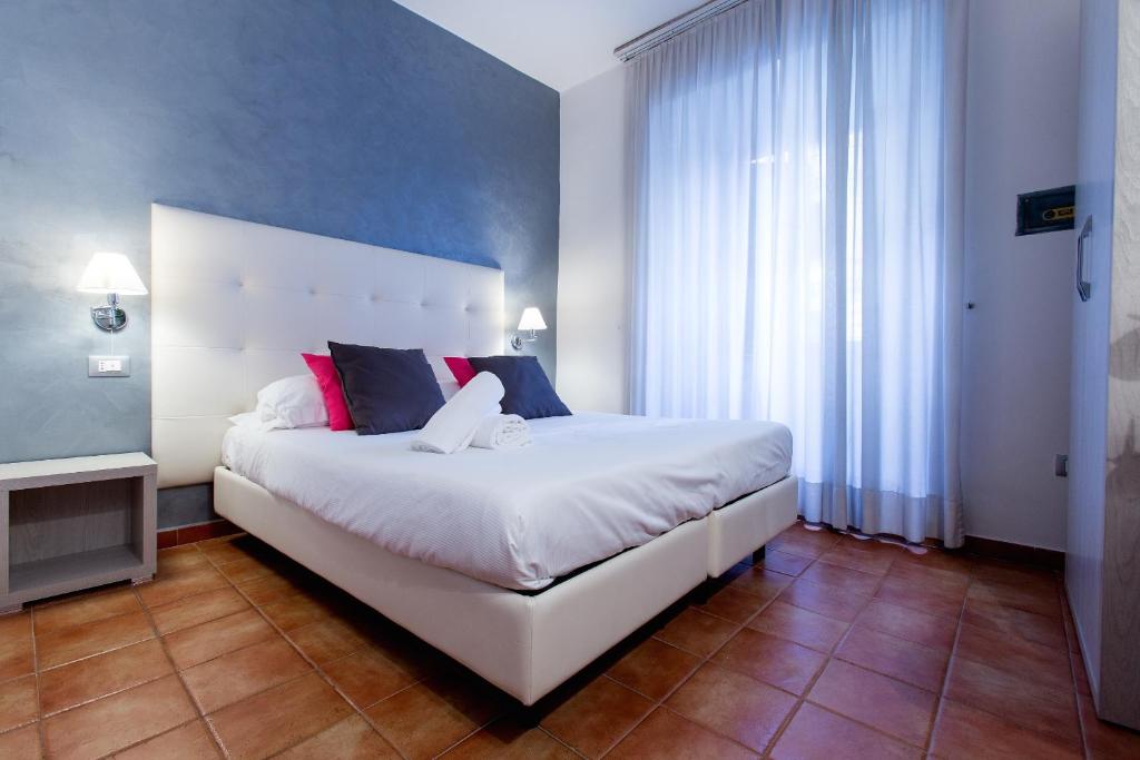 a bedroom with a large white bed and a television at Hotel Gabriella in Rome