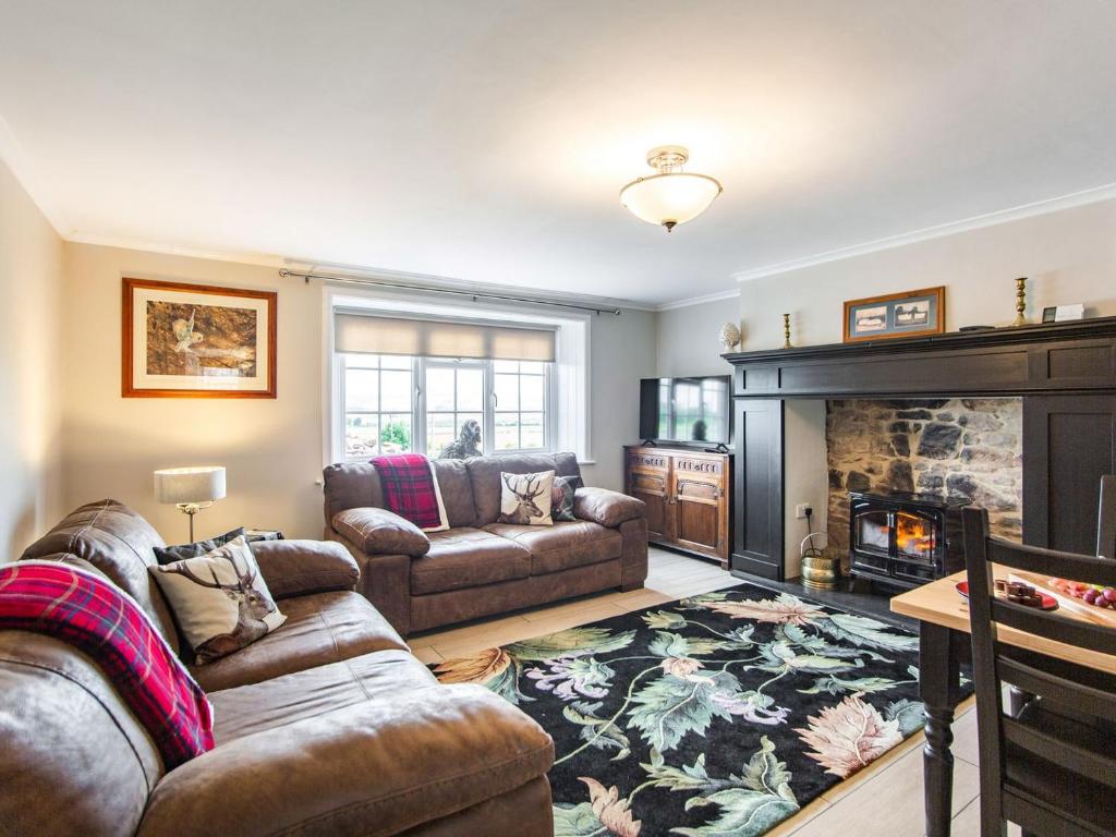 a living room with two couches and a fireplace at Flossys House -uk35020 in Chatton