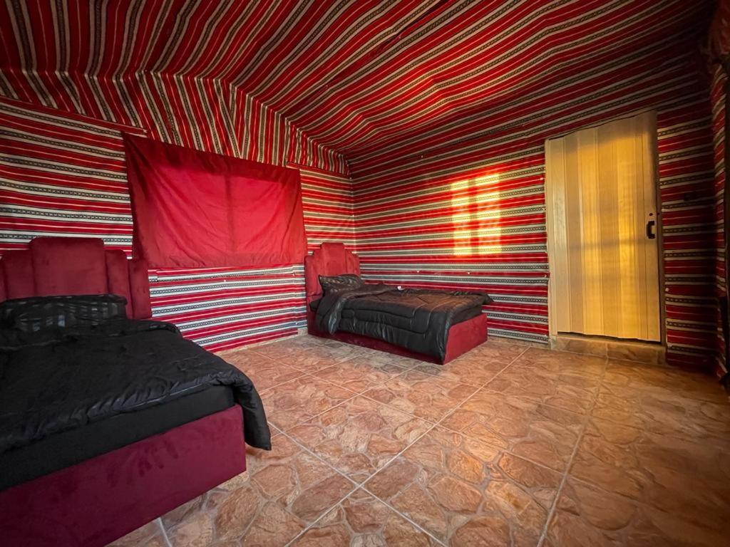 um quarto com 2 camas e um tecto com riscas vermelhas e brancas em Dana Sunset Eco Camp em Dana