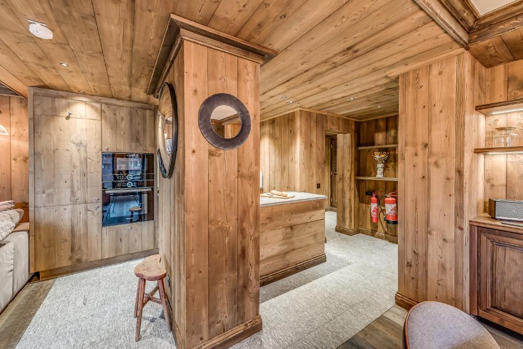 a log cabin kitchen with wooden walls at HOTEL LE VAL D&#39;ISERE in Val-d&#39;Isère