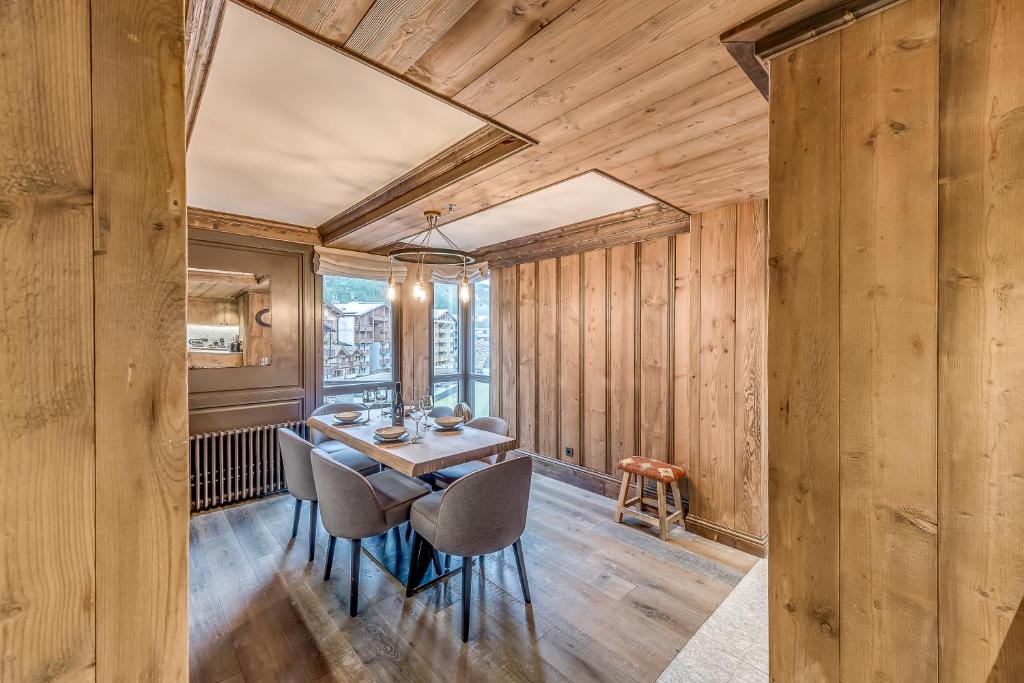 a dining room with wooden walls and a table and chairs at HOTEL LE VAL D&#39;ISERE in Val-d&#39;Isère