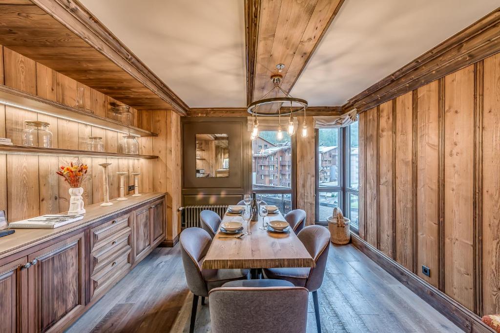 a dining room with a table and chairs and wooden walls at HOTEL LE VAL D&#39;ISERE in Val-d&#39;Isère