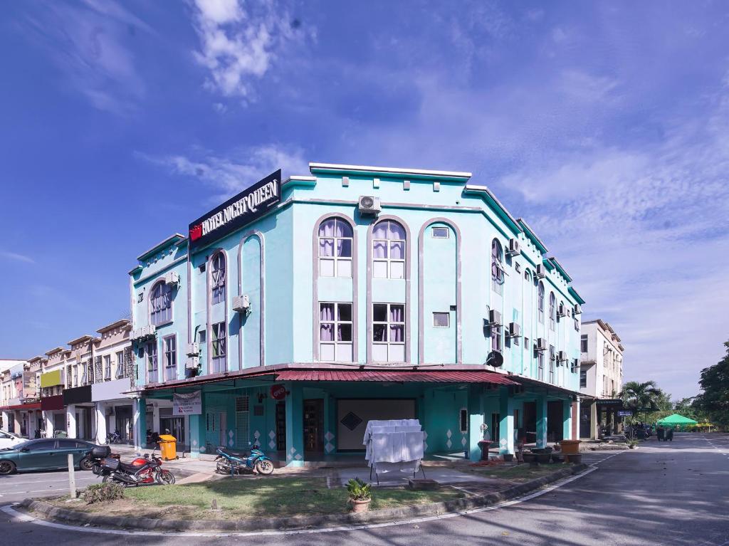 a blue and white building on the corner of a street at Super OYO 90516 Hotel Night Queen salak Tinggi in Sepang
