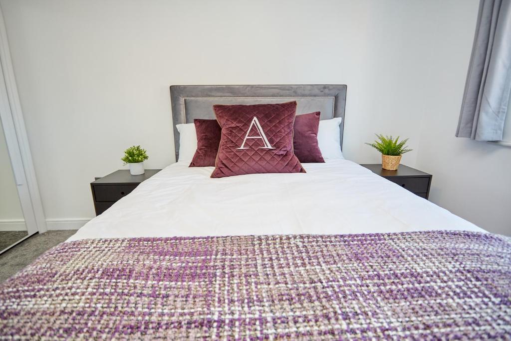 Dormitorio con cama con almohada y letra a en Cosy,Modern and Relaxing 3 bedroom house with parking, en Mánchester