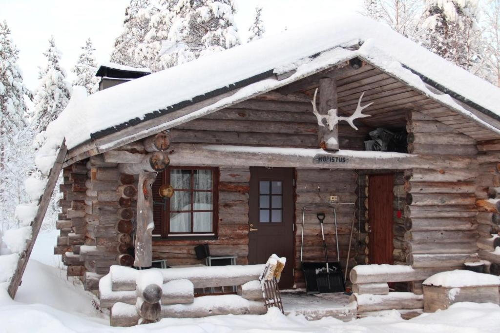 eine Blockhütte im Schnee mit einem Elch auf dem Dach in der Unterkunft Kopistus in Syöte