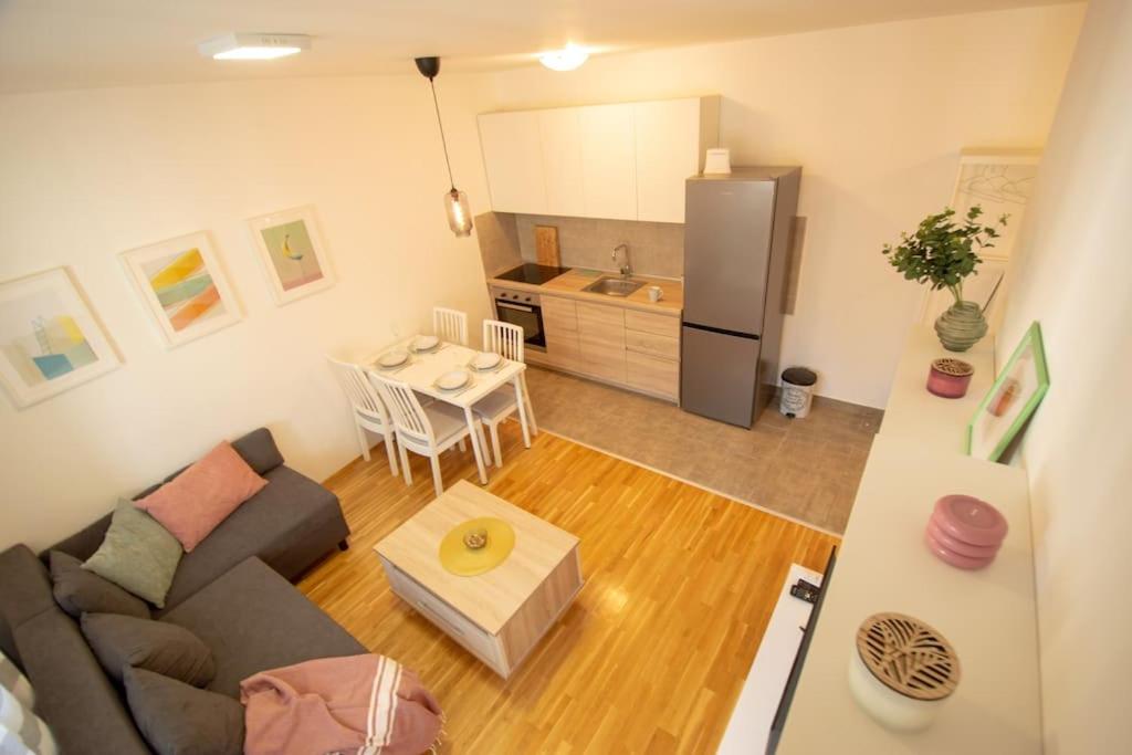 sala de estar con sofá y cocina en WHITE FIELDS-Central 2-bdrm apartment with parking, en Novi Sad