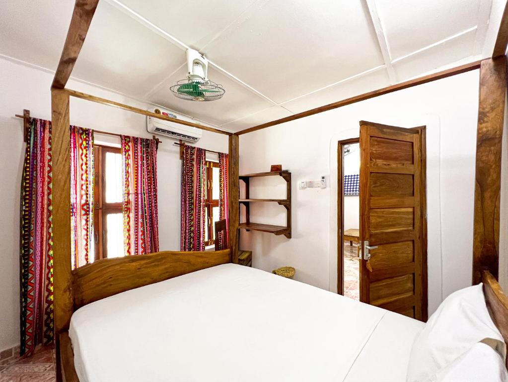 a bedroom with a bed and a window at Shoki Shoki Hostel in Zanzibar City